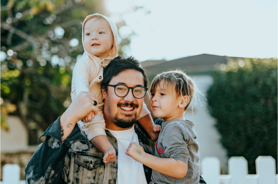 Man holding his two young kids/