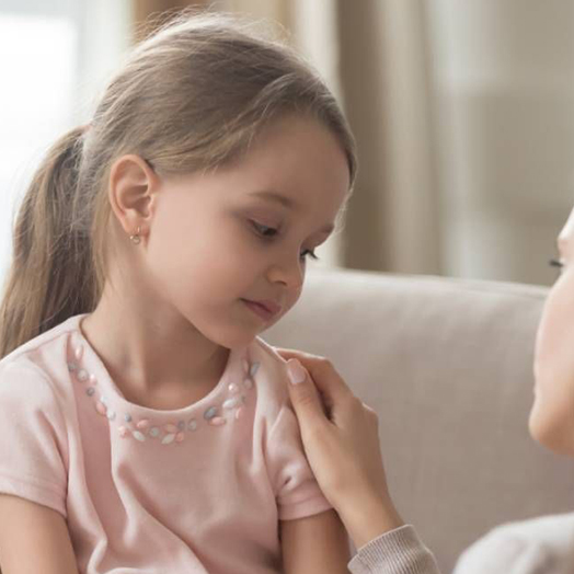 Young girl being comforted by her mother