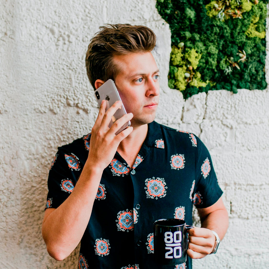 Man with an urgent legal need talking to a lawyer on his cellphone as he stands outdoors.