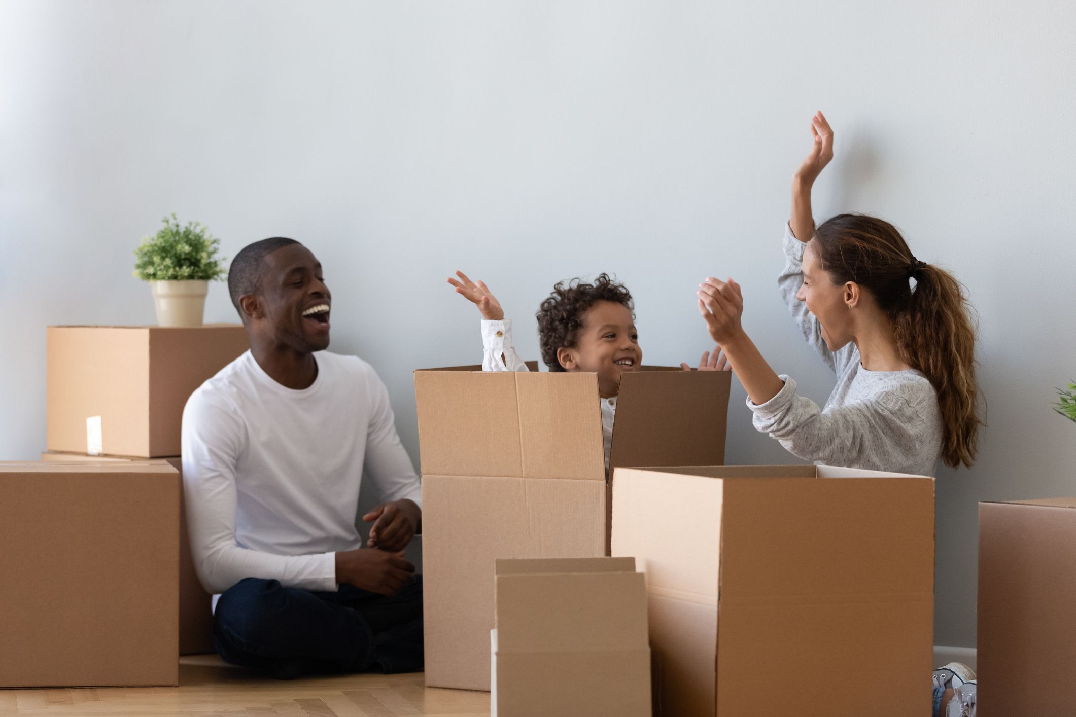 Mother & father playing with son in moving boxes