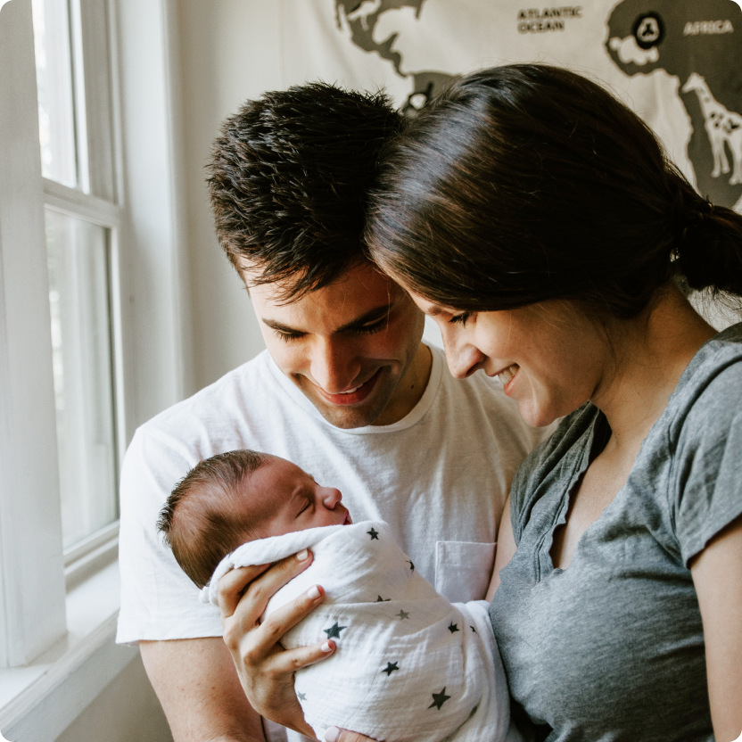 Madre sosteniendo al bebé mientras el padre mira