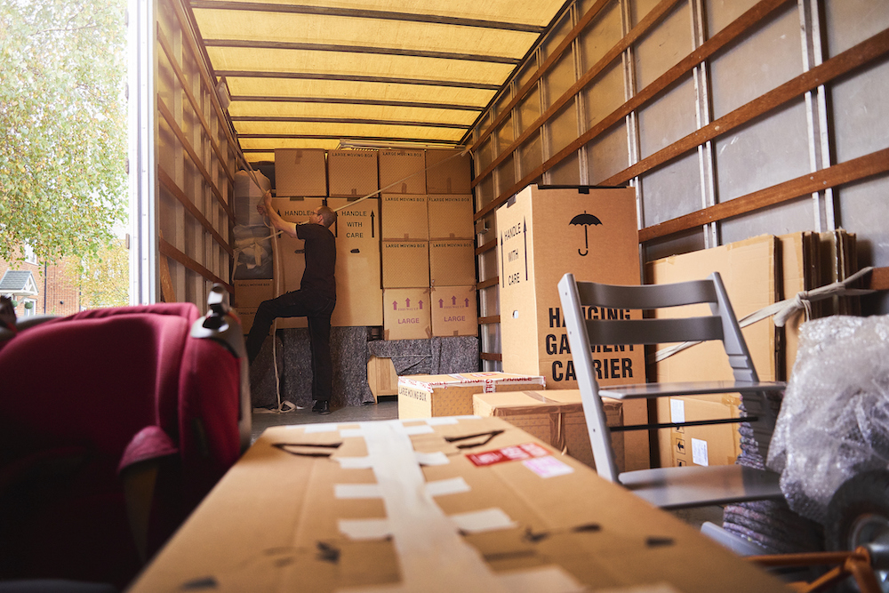 Moving truck worker securing boxes