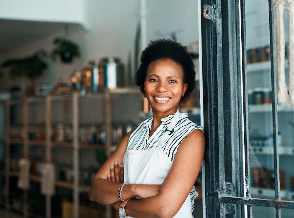 Young business owner standing in doorway of her shop