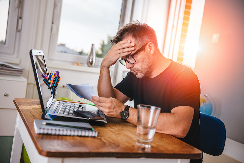 Stressed man reviewing bills