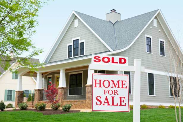 House with a Sold Home for Sale sign in the front yard.