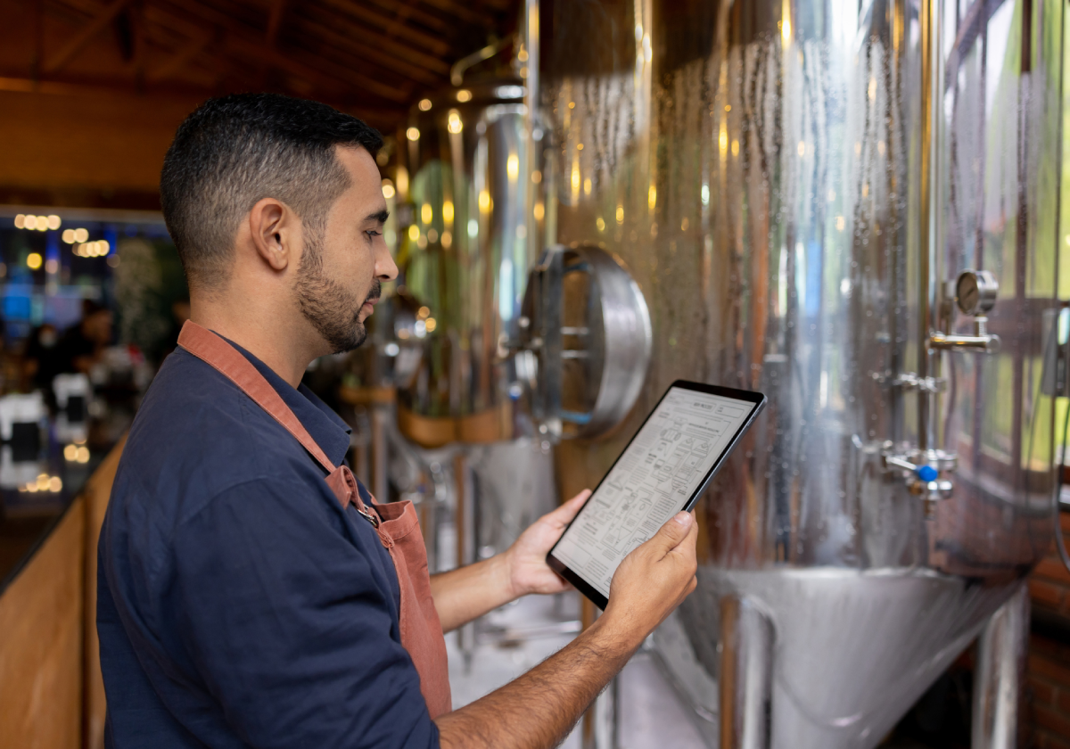 Man monitoring brewery fermentation vessels