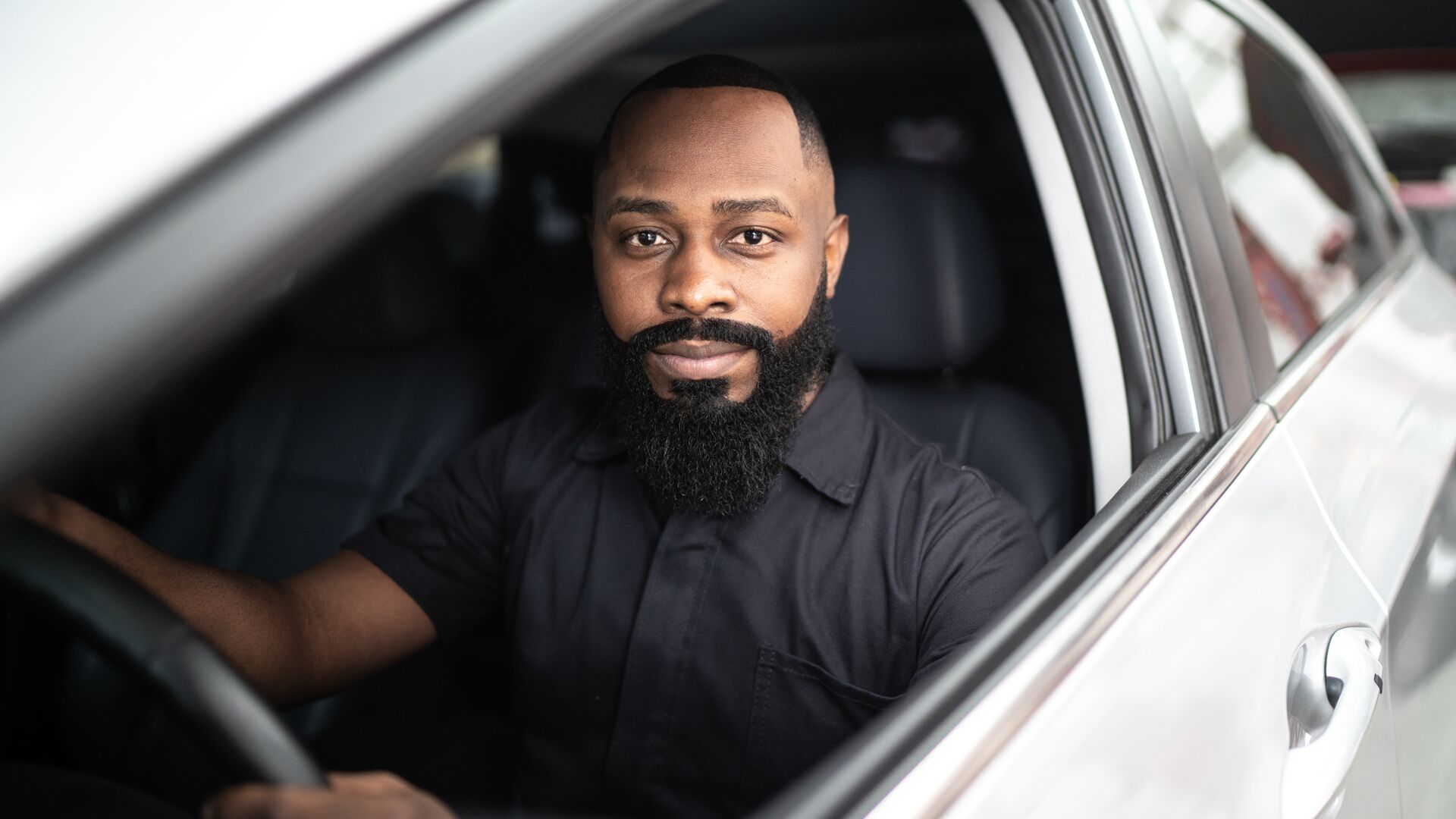 Man looking at camera driving car