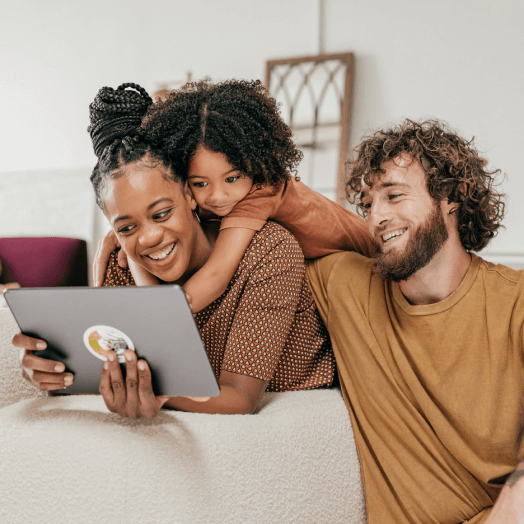 Mother, father and young child looking at a tablet computer as the create an estate plan Last Will and Testament.