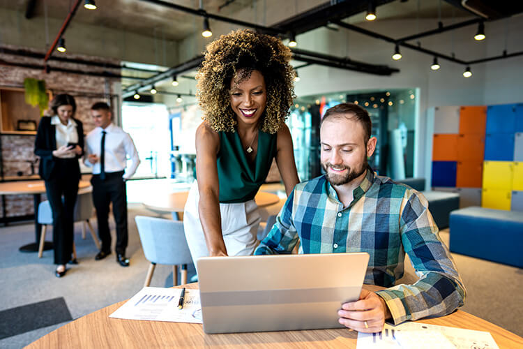 Business owner talking to an employee in the office.