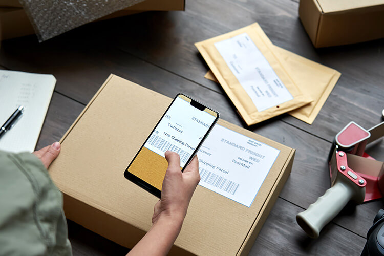 A person scanning the barcode on a box with their phone.