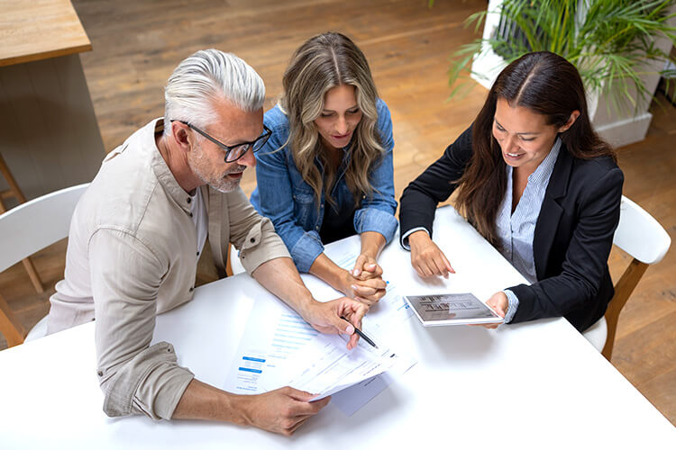 Man and woman working with female lawyer on debt collection negotiations.