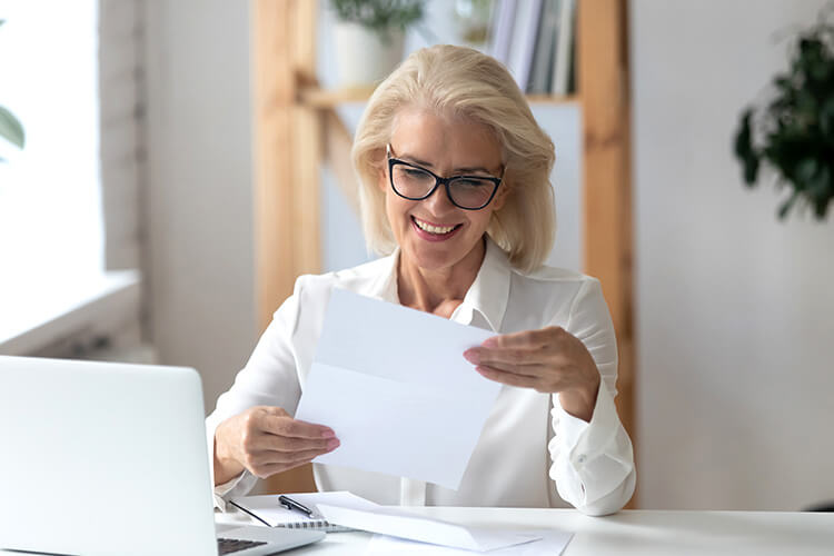 Woman smiling while she's reading a document