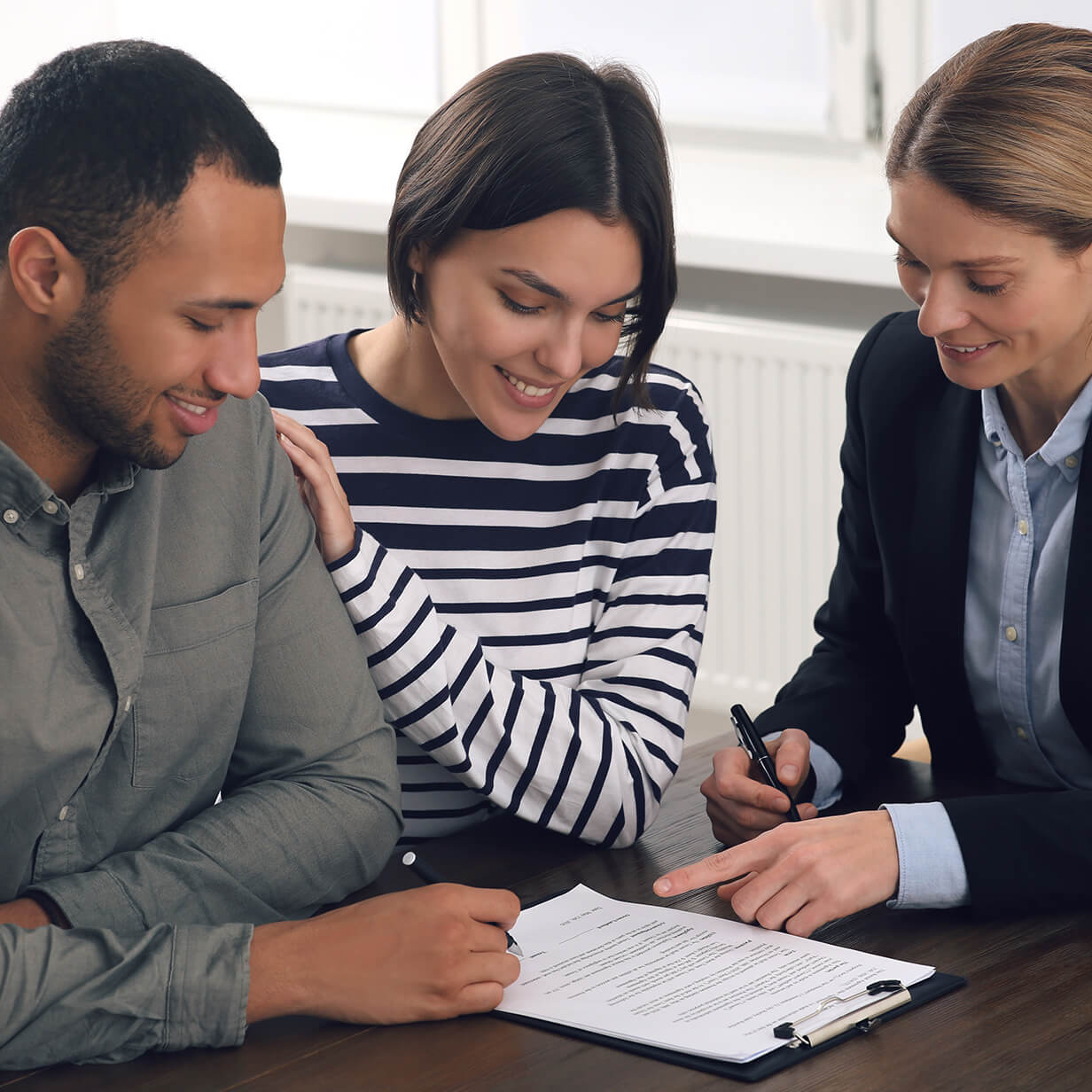 A woman reviewing lease documents with a couple