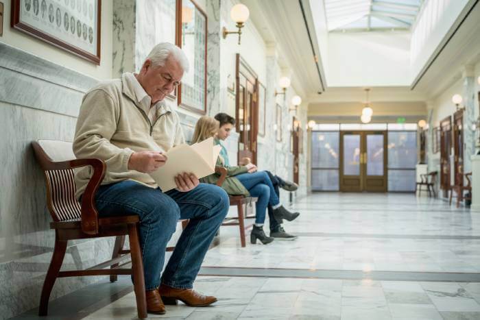 A small business owner sitting outside a Small Claim courtroom preparing for his case.