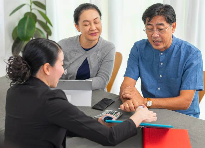 Man and his wife looking at tax information on a lawyer's tablet.