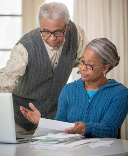 Couple looking at a laptop to understand voluntary car repossession process.